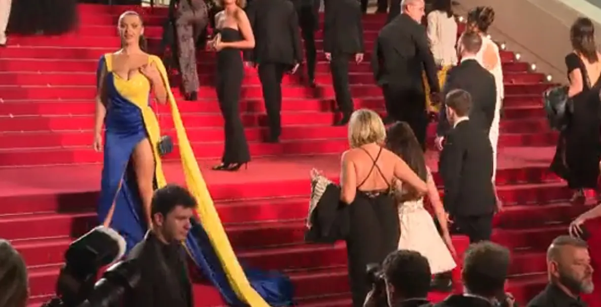 Protest pe covorul roșu de la Cannes. O femeie îmbrăcată în culorile steagului ucrainean s-a stropit cu vopsea roșie
